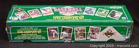 Photo of the long rectangular green cardboard box showing the front and side, sealed with plastic wrap and decorated with images of baseball players and the text '1990 Complete Set'.