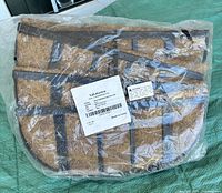 Four metal wall baskets with attached coco liners, individually sealed in plastic, placed on a green tarp.