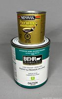 Two unopened cans: Minwax PolyShades wood stain and Behr Premium Plus interior paint.