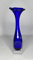 Front view of the cobalt blue and clear glass art vase showing the flared top and rectangular base.