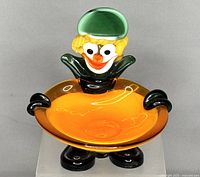 Front view of Murano art glass clown ashtray showing colorful clown figure holding orange dish.