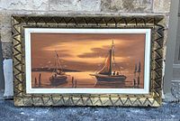 Framed oil painting showing boats, sunset, and signature. Full view of artwork and frame.