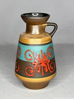 Front and side view of the vintage West German Fat Lava vase jug showing its turquoise band with raised red swirls and metallic gold glaze.