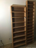 View of two wood bookshelves side by side against a wall, showing overall size and shape, natural wood finish.