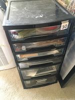 Full view of black plastic storage tower with six transparent drawers, numbered 30