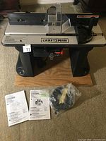 Overview of router table including router, manuals, and accessories.