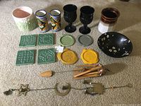 View of all items in the set including coasters, mugs, glass goblets, ceramics, and wind chimes arranged on carpet