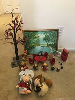 Overall view of lot items including dolls, figurines, furniture, decorative tree, and framed painting