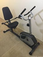 Side view of Marcy stationary recumbent exercise bicycle showing seat with backrest, handlebars, pedals, and main frame.