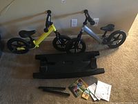 Overview of two Strider balance bikes, rocker attachment, support bars and manuals