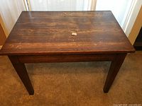 Full view of the vintage wood library table showing rectangular top and four sturdy legs with natural wood grain and distressed finish.