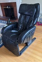 Front angle view of black leather massager recliner chair