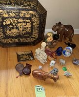 Overall view of octagonal lacquer box, painted eggs in bowl, carved hippo and assorted figurines