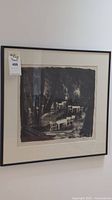 Full frontal image of framed black and white print within black metal frame and mat