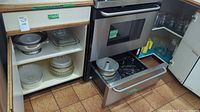 Kitchen drawer and cabinet with stainless steel bowls, glass bakeware dishes, and storage jars visible.