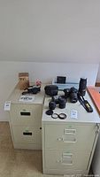 Lot items on two filing cabinets: camera, lenses, boxes, filters