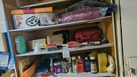 Wooden shelves with various car cleaning liquids, sponges, funnels, brushes, and red fuel containers