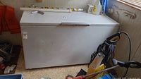 Front view of white chest freezer with surrounding tools