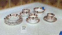 Full lot displayed, showing two teacups with saucers, six small plates, and bowl arranged on countertop.
