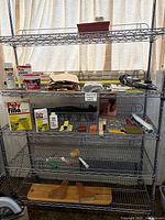 Full view of metal shelving unit with assorted renovation and painting supplies including Polyfilla, spackling, sandpaper, brushes, and rollers.