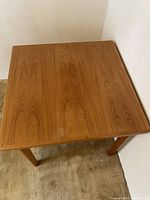 Overall top view of square teak table showing color and grain