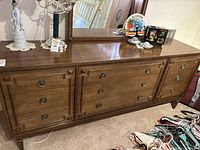 Full front view of the vintage wooden dresser with nine drawers and mirror, showing its overall condition and design.