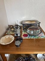 Photo showing entire collection including warming dish, serving dishes, sugar and creamer servers, salt and pepper shakers, small containers and an off-white ceramic dish.