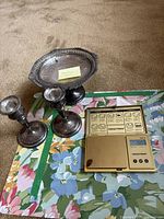 Tray and two candlestick holders alongside digital scale showing all components