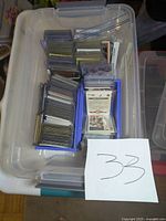 Interior of one large clear tote showing hundreds of hockey and basketball cards in individual sleeves and small storage boxes.