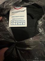 Close-up photo of grey hoodie tag showing size large and 100% preshrunk cotton content