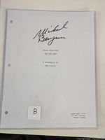 Front view of the script cover showing typed title and author details on white paper inside hard plastic sleeve.