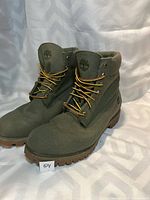 Pair of green Timberland boots viewed from front and side showing overall condition and style.