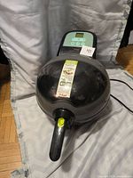 Front and top view of the T-fal ActiFry Express air fryer showing digital control panel, handle, and closed lid with manufacturer label.