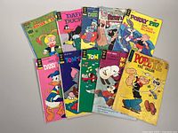 Ten assorted vintage comic books including Popeye, Mickey Mouse, Porky Pig with Bugs Bunny, Daffy Duck, Walt Disney characters, Tom and Jerry, and Donald and Daisy Duck.