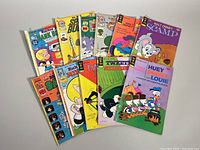 Ten vintage comic books arranged in two rows with colorful illustrated covers featuring classic cartoon characters including Scamp, Gazoo, and Richie Rich. Covers show age-related wear.