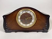 Front view of the Seth Thomas mantle clock showing the domed wooden case with carved side accents, brass bezel and clock face with Arabic numerals.