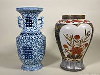 Front view of two Asian vases: blue and white Chinese double handle vase on the left, Kutani porcelain vase with floral and gold accents on the right.