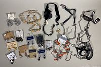 Overview of assorted costume jewelry including multiple earrings, necklaces, bracelets, with some items still on display cards