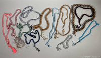 Photo showing multiple assorted prayer bead necklaces in various colors and styles