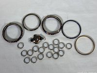 Full lot overview showing 4 bangles, 12 rings, and koi fish keychain pendant laid out on fabric