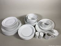 Full set overview showing stack of plates, bowls, salt and pepper shakers, creamer, sugar bowl with lid, and gravy boat.