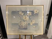 Full view of the 1970s framed floral wall art showing the entire piece with flowers in a round vase, framed and glass-protected.