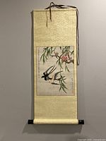 Full view of the mounted Chinese scroll painting showing birds and flowering branches on silk mounting.