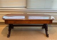 Front view of full table showing top surface, apron, carved cabriole legs and stretcher base