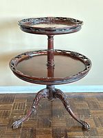 Full view of the two-tier mahogany round serving table showing overall structure and claw feet support.