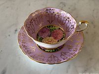 Top view of teacup centered in matching saucer showing chrysanthemum flower pattern inside and on saucer