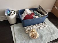 Overall view of the bath lot items including towels, bath mats, hot water bottle, and shell decor bowl on a towel