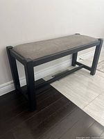 Full side view of boot bench showing black frame and gray padded top
