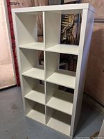 Front view of white IKEA Kallax shelving unit with 8 open cubes.
