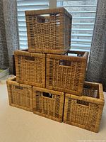Six IKEA Branas rattan baskets stacked showing sides and top handles